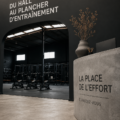 Femme souriante entrant dans une salle de sport, prête à s'entraîner.